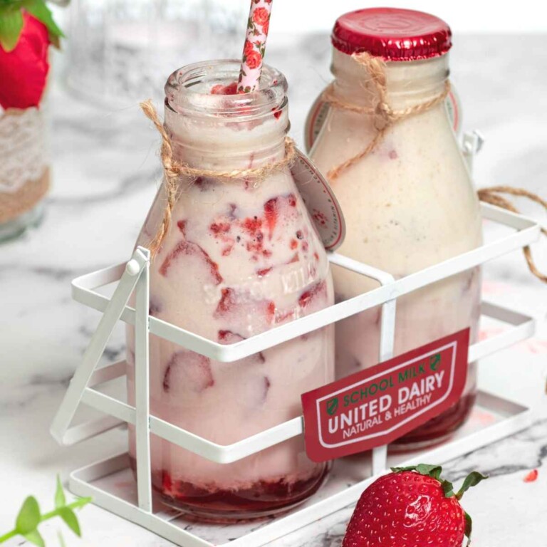 Two bottles of Korean strawberry milk in a milk crate
