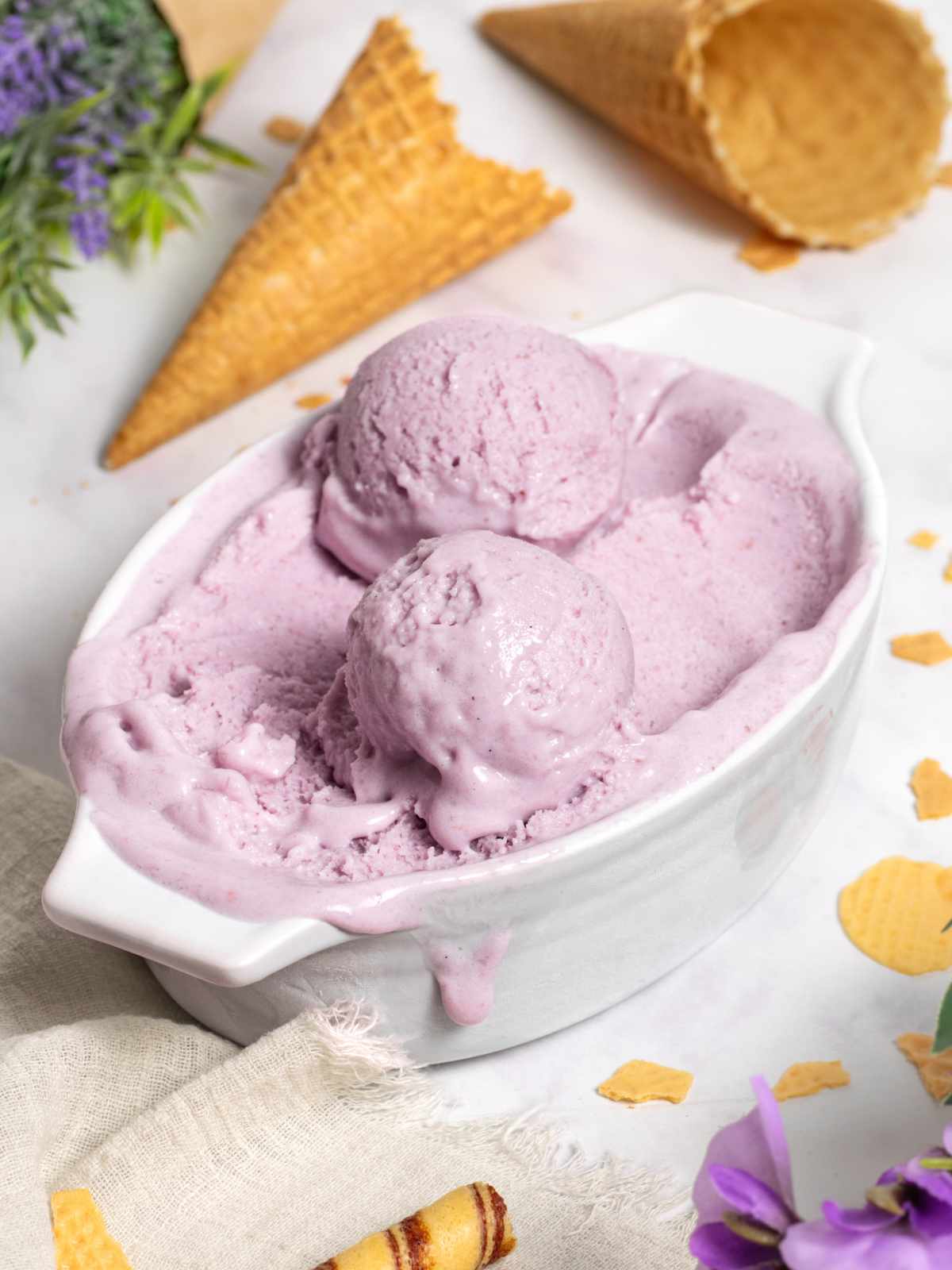 Double Scoop of Purple and Blue Ice Cream Cone on a White