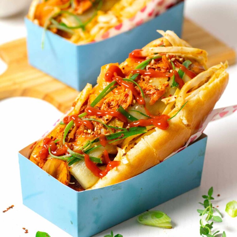 Kimchi hot dog topped with green onions and ketchup