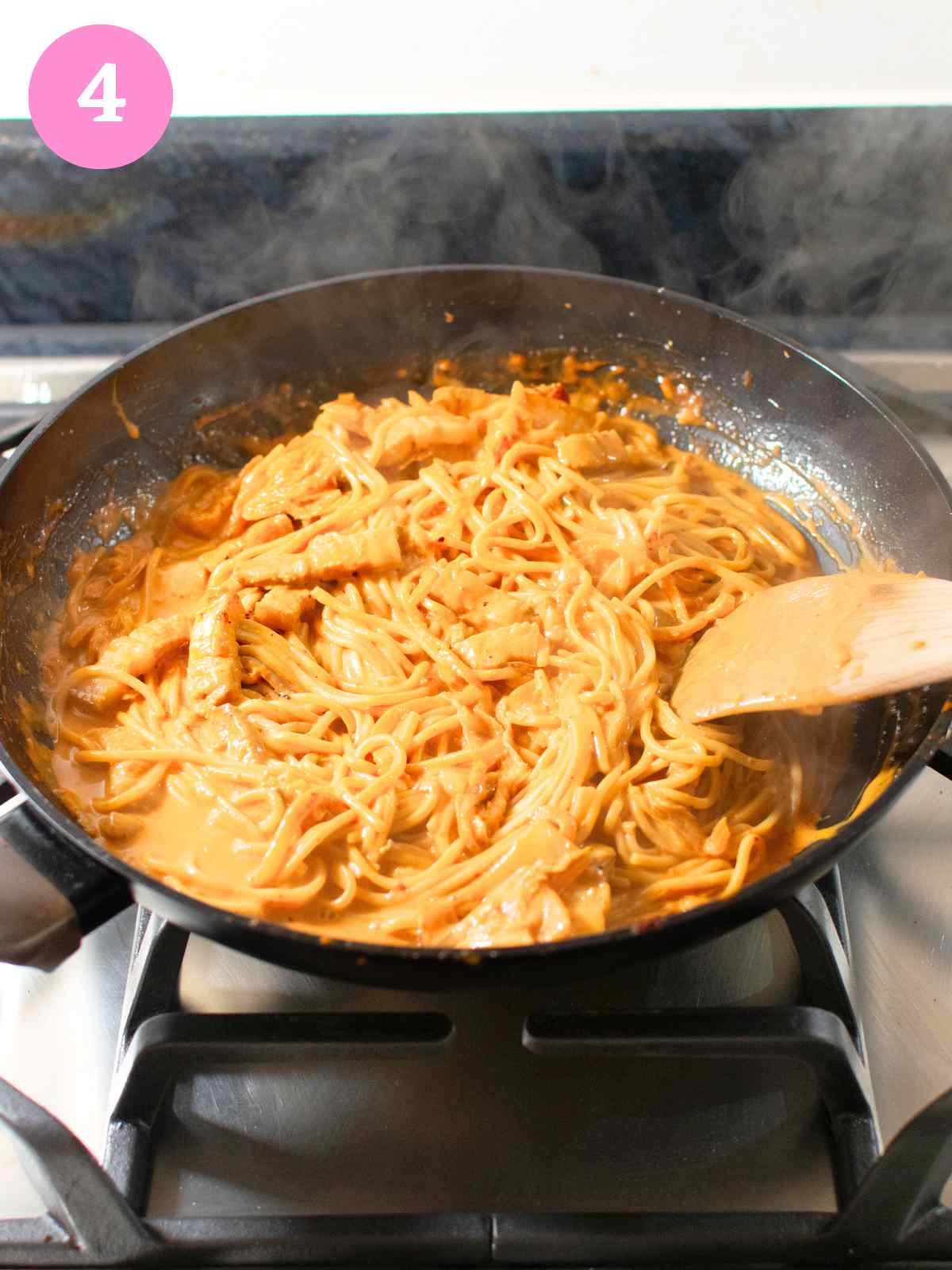 Creamy udon noodles with sauce in black pan