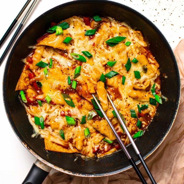 Rice cakes with melted cheese in a black pan