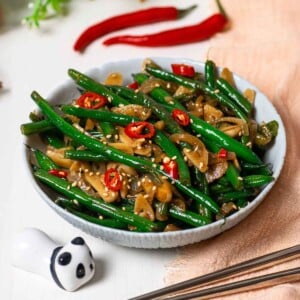 Korean green beans with onion and garlic and chili slices on top in a small bowl