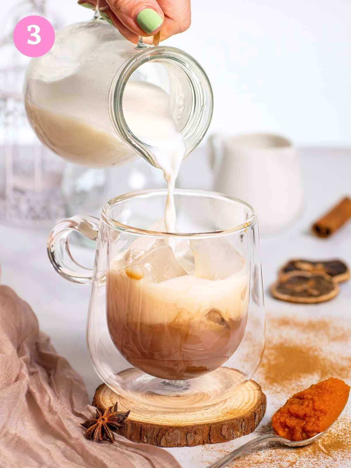 Pouring milk over chai concentrate in glass