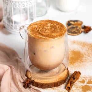 Pumpkin spice chai latte in glass with pumpkin spice on top